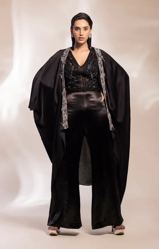 Black embroidery cape worn over jumpsuit